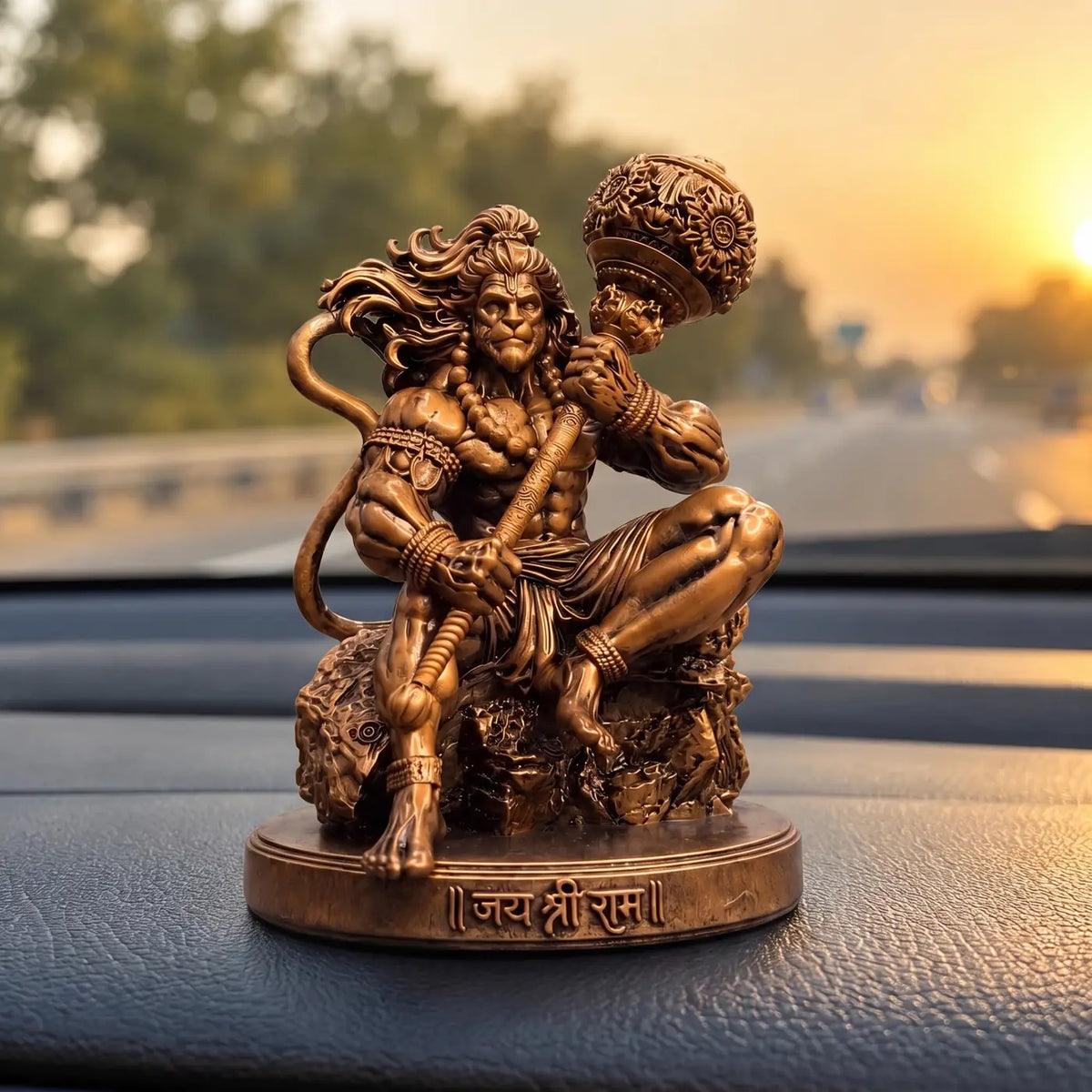 Mahabali Hanuman idol placed on a car dashboard at sunset