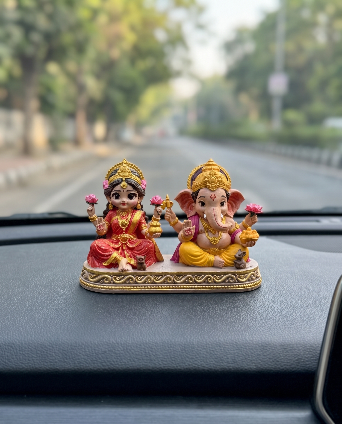 Laxmi Ganesh idol fixed on a car dashboard with adhesive base