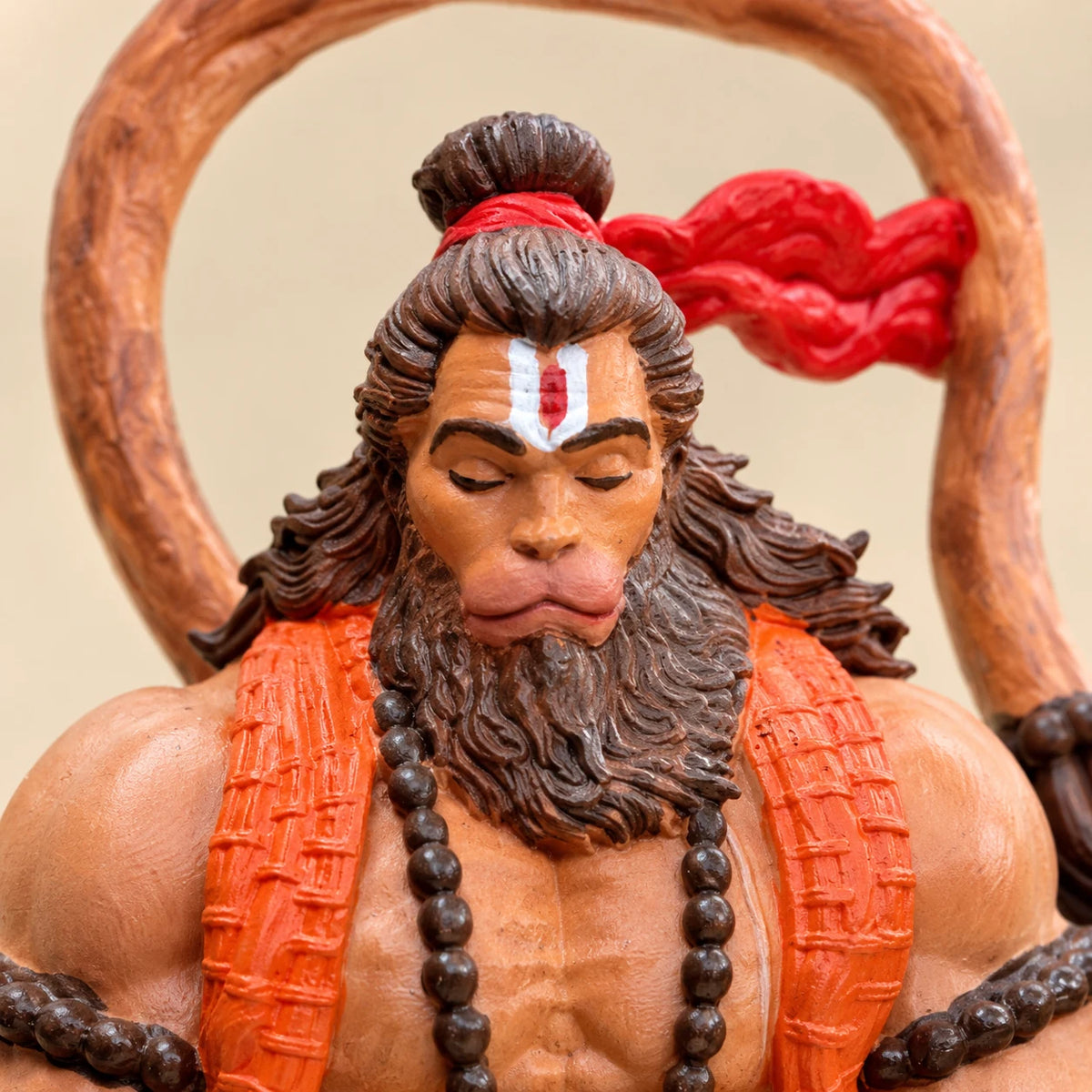 Close-up of Hanuman Ji's face with closed eyes and tilak