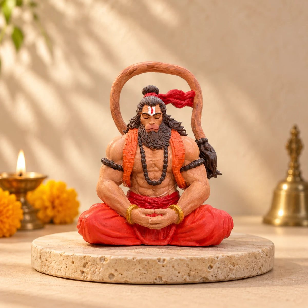 Ram Bhakt Hanuman Ji murti in a home mandir beside a diya and marigolds