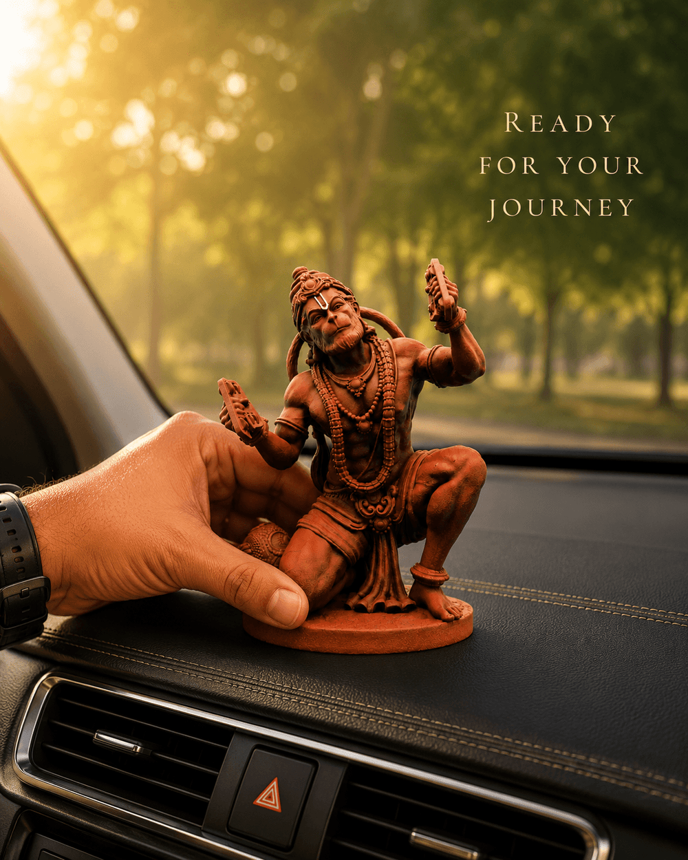 A hand placing the Ram Rasik Hanuman idol on a car dashboard