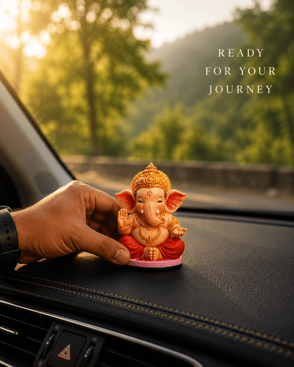 A hand placing the Bal Ganesha idol on a car dashboard