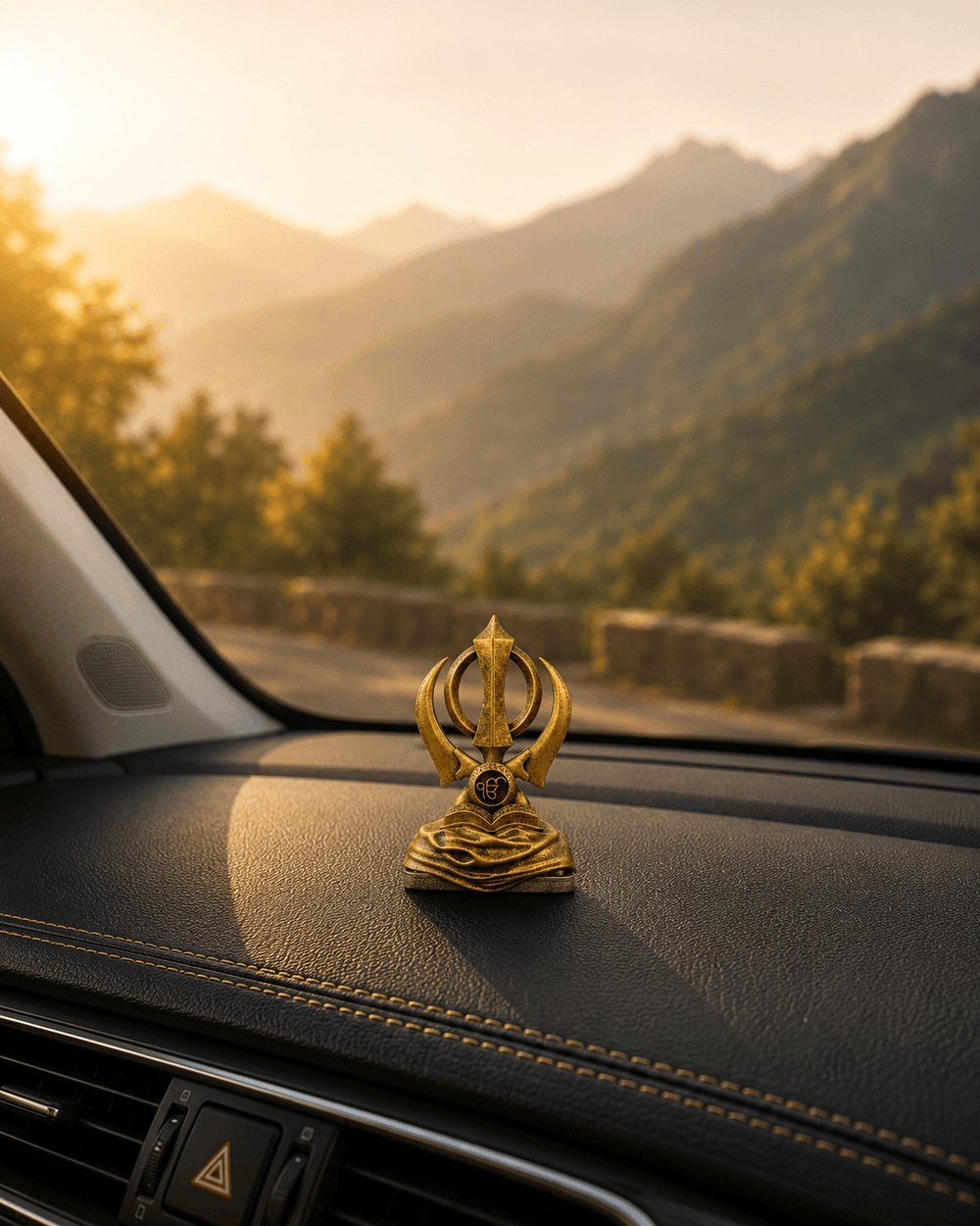The Khanda Sahib piece on a dashboard with hills beyond the windscreen