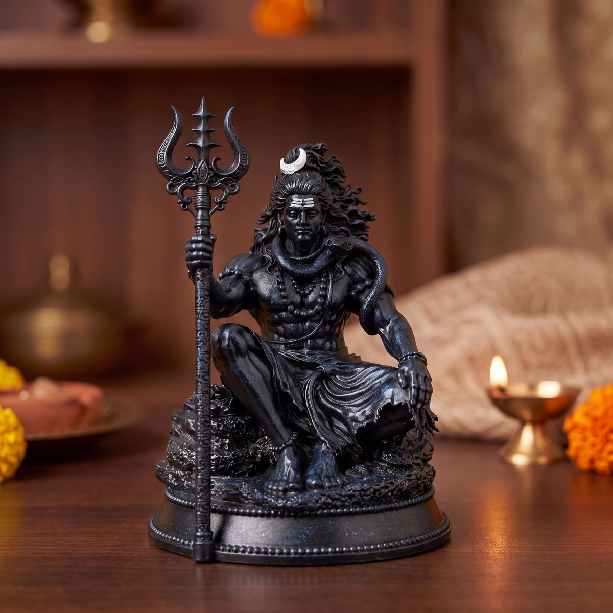 Mahadev Trishul Dhyan Idol, Black Edition — on a home mandir shelf with a lit diya